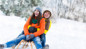 Couple,With,Sled,In,Snow
